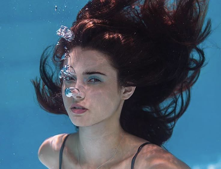 a woman with her hair in the air under water