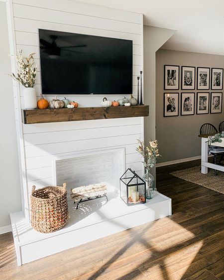 a living room filled with furniture and a flat screen tv mounted on the wall above a fireplace