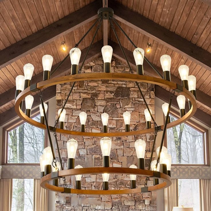 a large chandelier hanging from the ceiling in a living room with stone walls