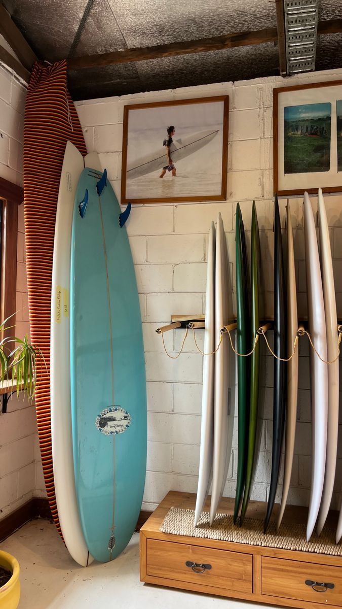 several surfboards are lined up against the wall