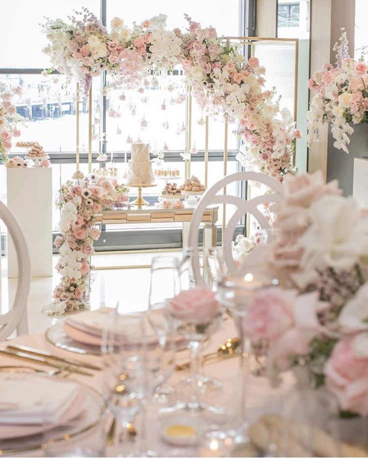 the table is set with white and pink flowers