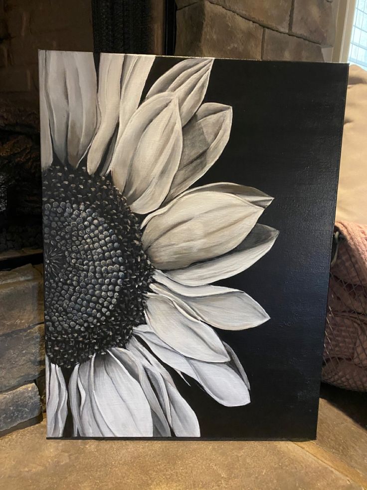 a painting of a sunflower on a black and white background is displayed in front of a fireplace