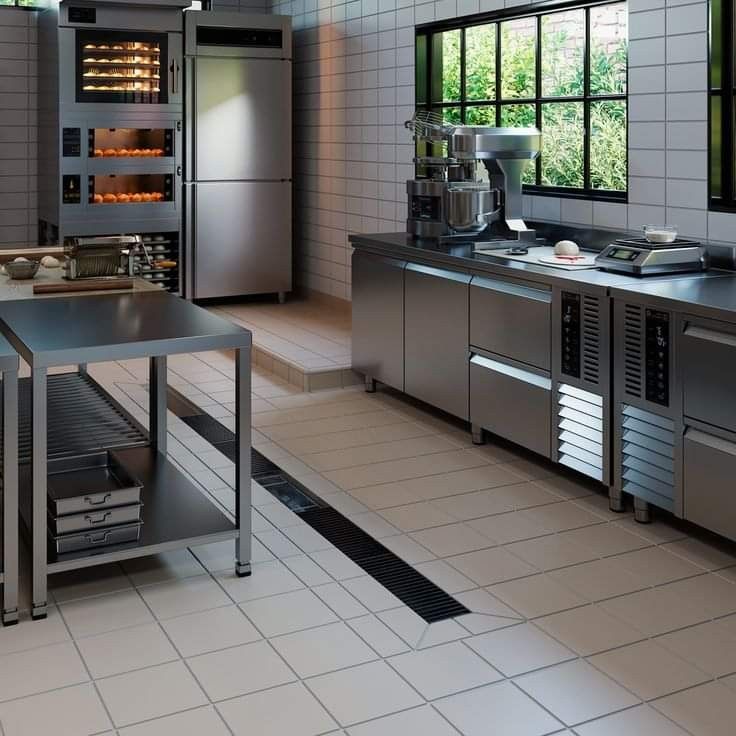 an industrial kitchen with stainless steel appliances and counter tops, along with tile flooring