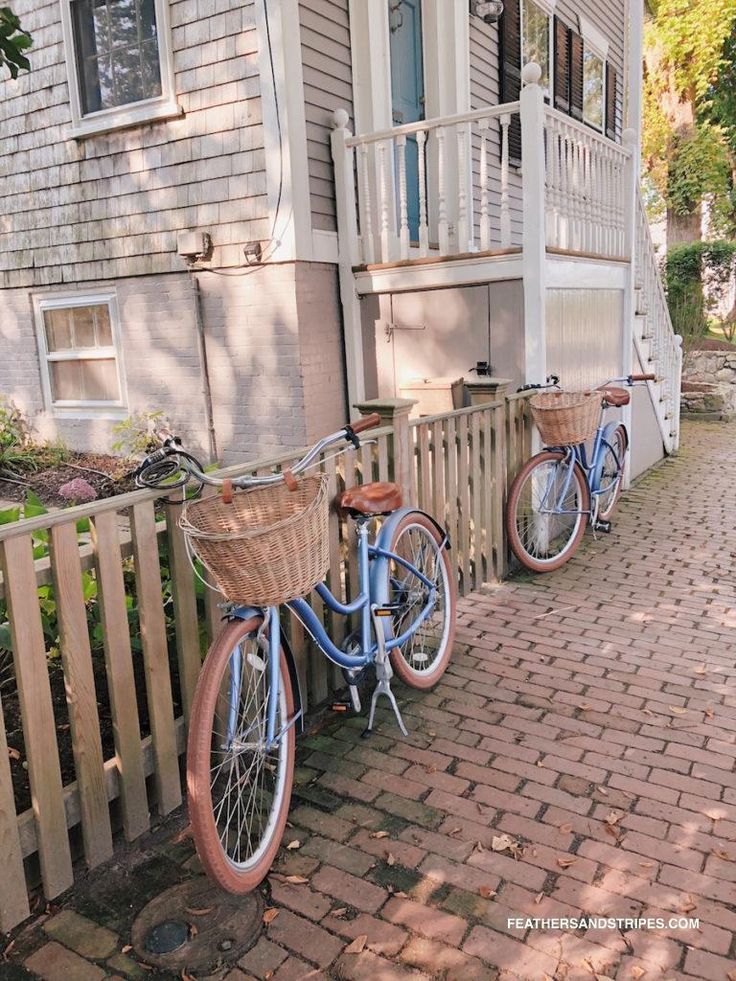 two blue bicycles parked next to each other on a brick walkway in front of a house