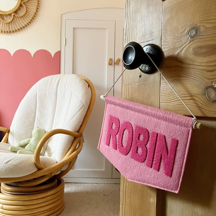 a room with two chairs and a pink sign hanging from the wall that says robin