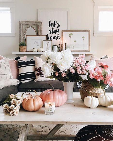 a living room filled with lots of furniture and flowers on top of a coffee table