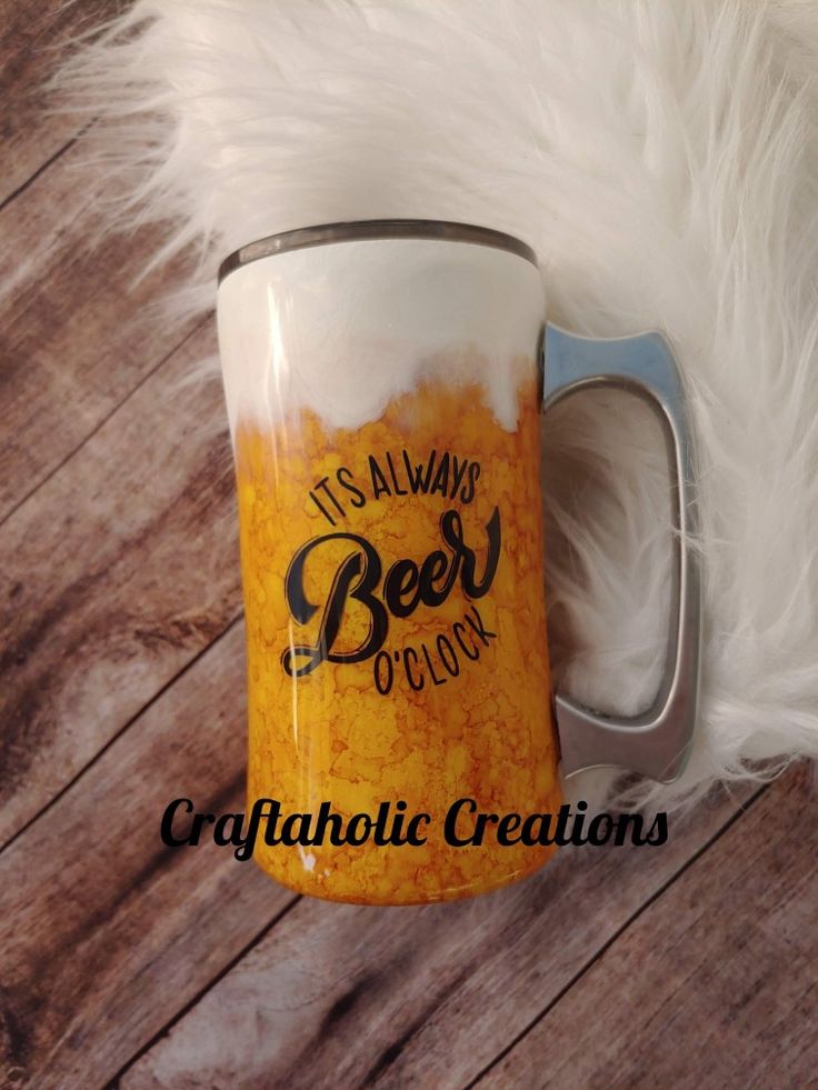 a beer mug sitting on top of a wooden table next to a white fluffy animal