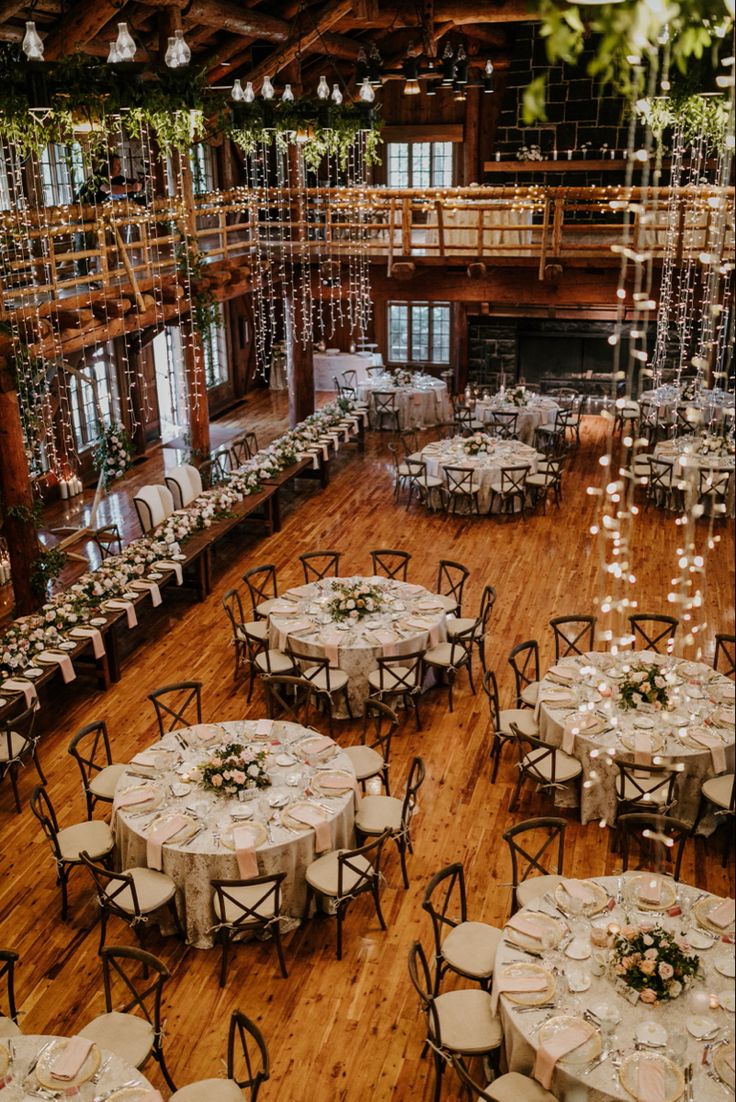 an indoor venue with tables and chairs set up for a formal dinner or wedding reception