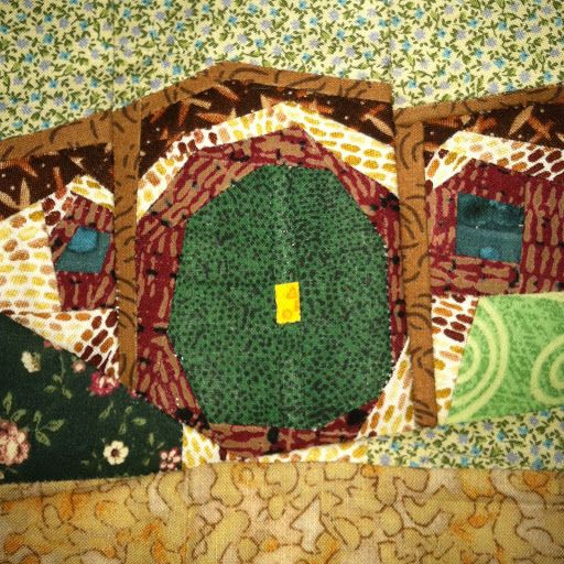 a quilted wall hanging with an image of a green door on it's side