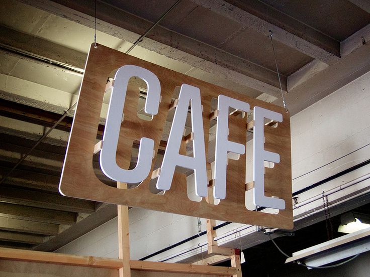 a sign that says cafe hanging from the ceiling