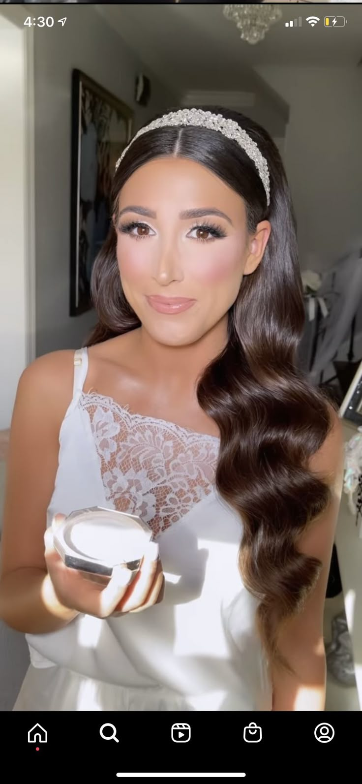 a woman in a white dress is holding a bowl and looking at the camera while wearing a tiara