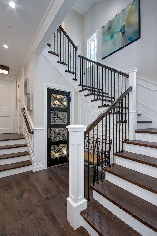 a staircase leading up to the second floor in a home with hardwood floors and white walls