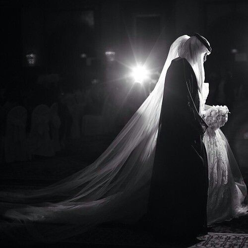 a bride and groom are walking down the aisle at their wedding in black and white