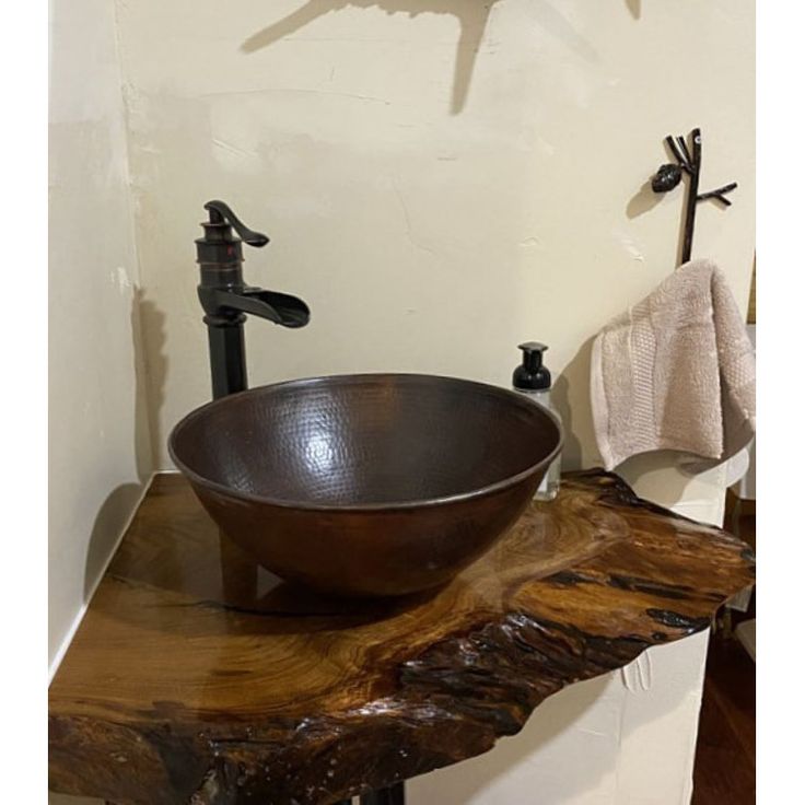 a bowl sink sitting on top of a wooden counter next to a faucet