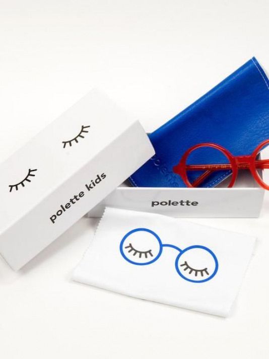 a pair of red eyeglasses sitting in a box next to some fake eyelashes