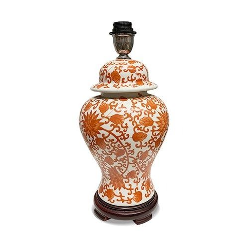 an orange and white vase sitting on top of a wooden stand