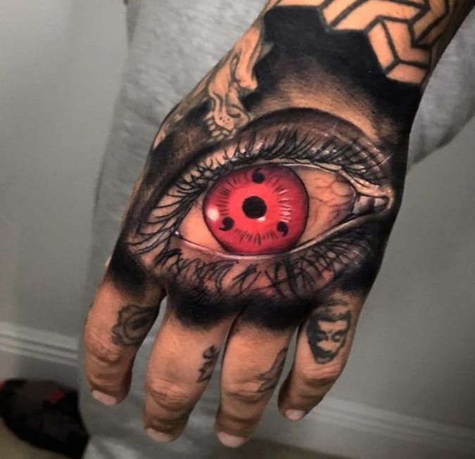 a man's hand with an eye tattooed on it