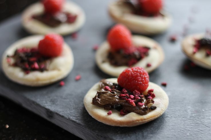 small desserts with raspberries and chocolate spread on the top are ready to be eaten