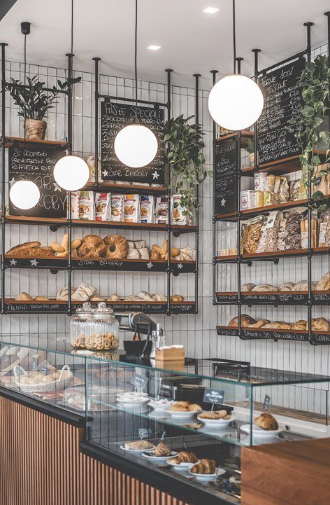 a bakery with lots of breads and pastries on display behind the glass counter