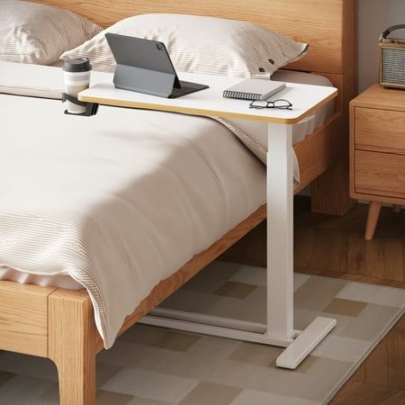 a bed with a laptop on top of it next to a night stand and nightstand