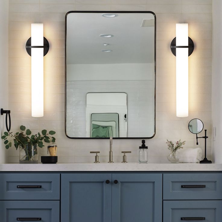 a bathroom vanity with two mirrors and lights