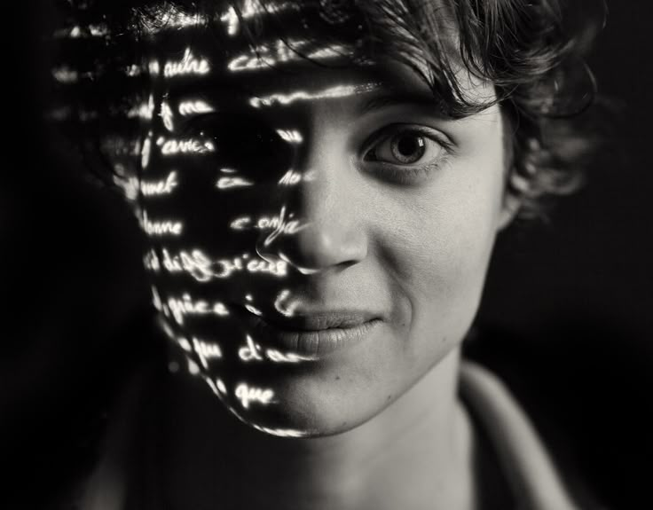 a woman's face is shown with words projected on her face and in the background