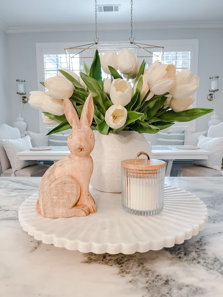 a table with flowers and a bunny figurine on it