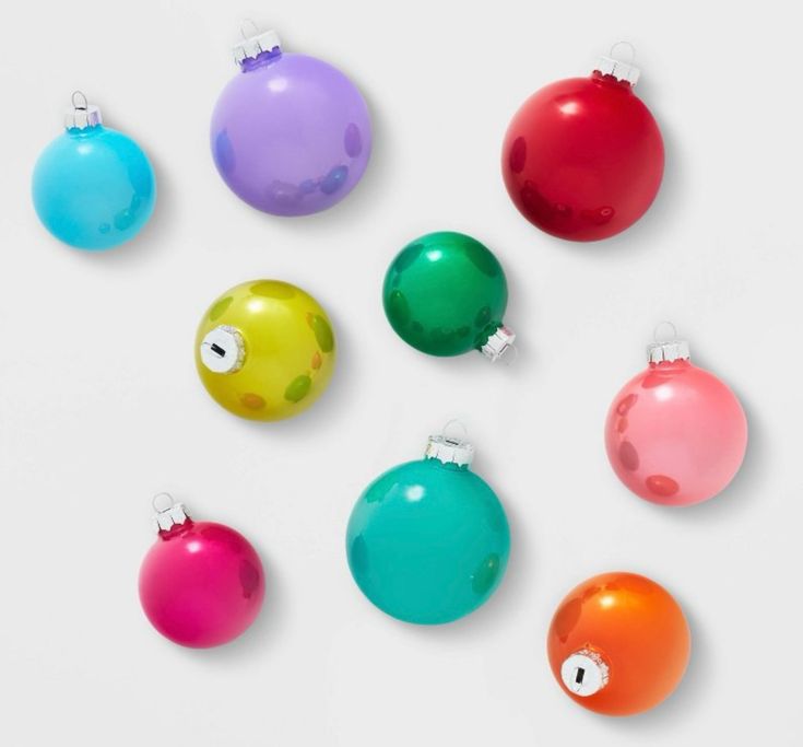 six different colored christmas ornaments on a white surface