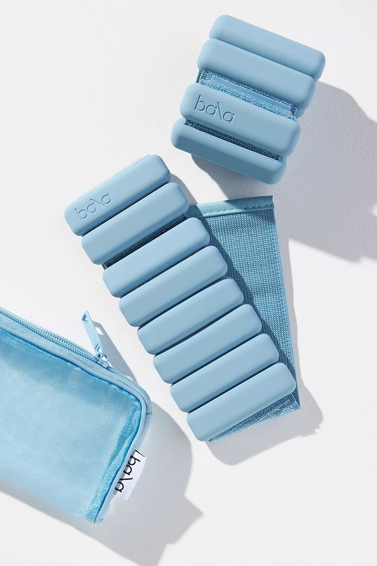 two pairs of baby blue shoes sitting on top of a white table next to a wallet