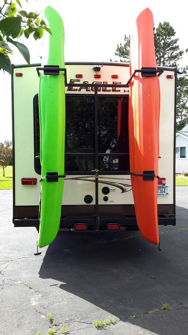 two surfboards are attached to the back of a camper