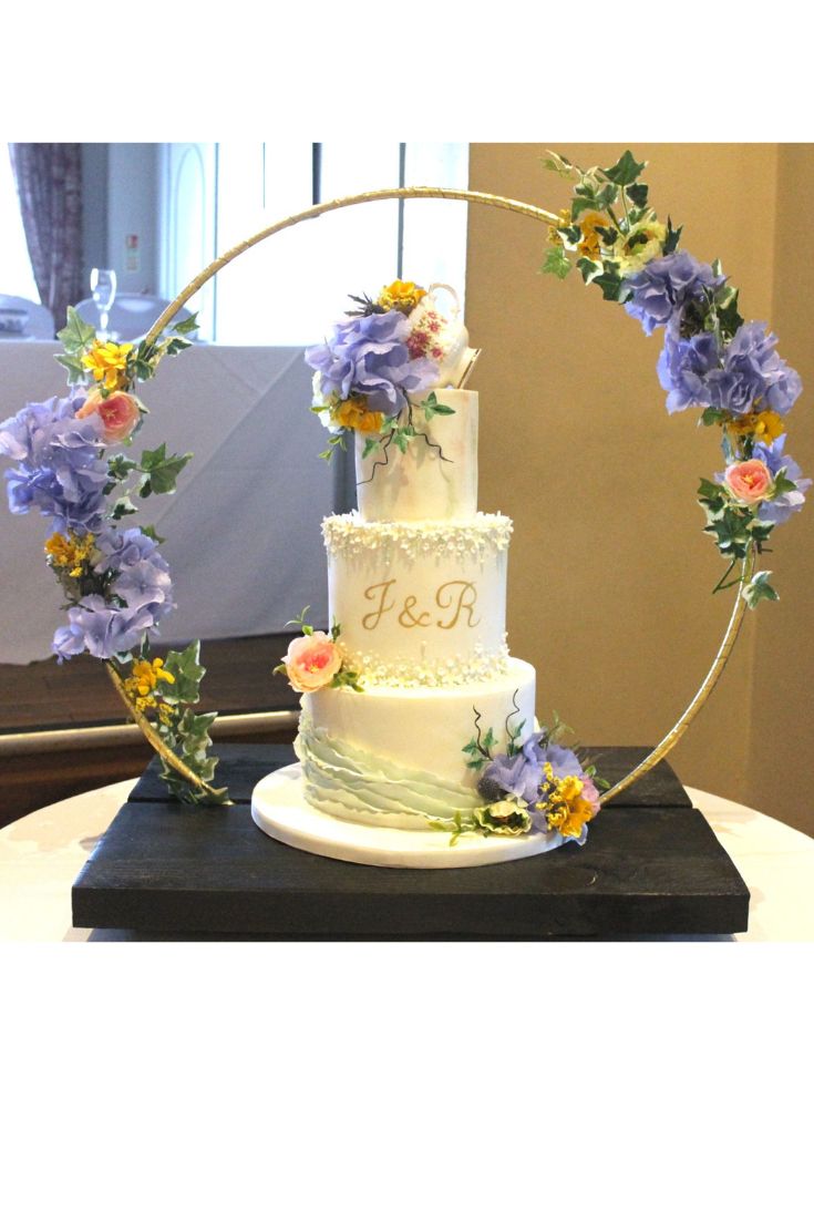 a wedding cake decorated with flowers on a table