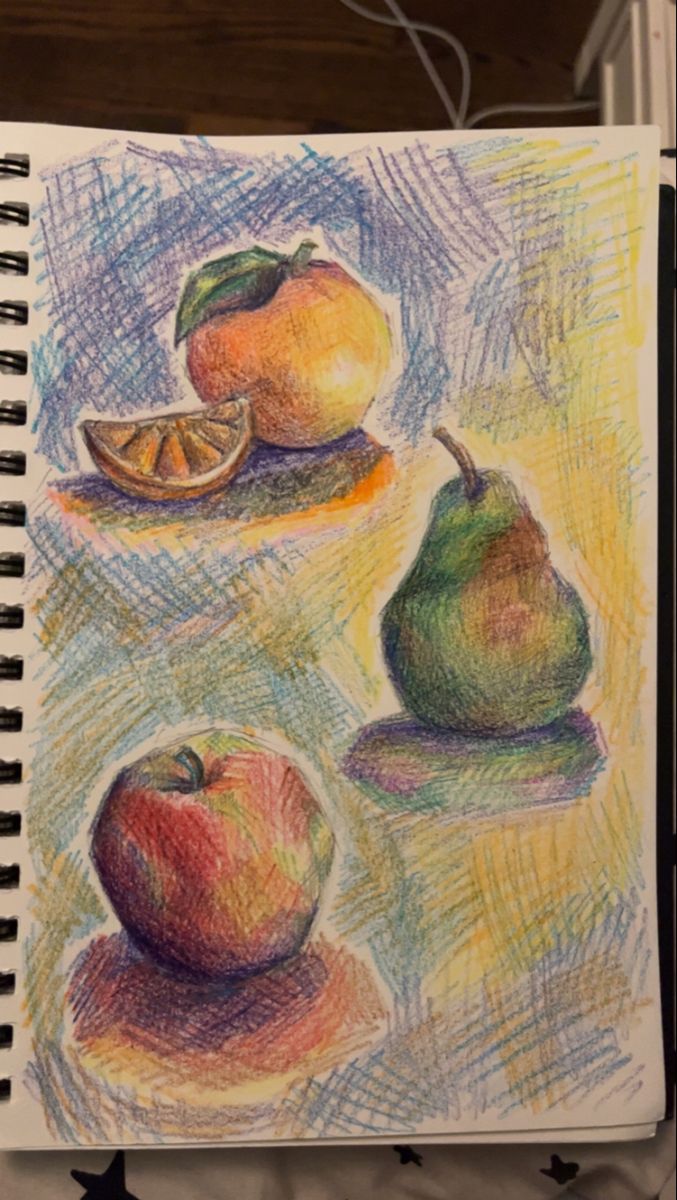 an open notebook with colored pencils and drawings of fruit on it, sitting on a table