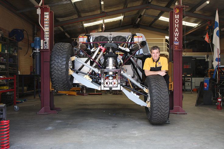 a man sitting on top of a large vehicle in a garage