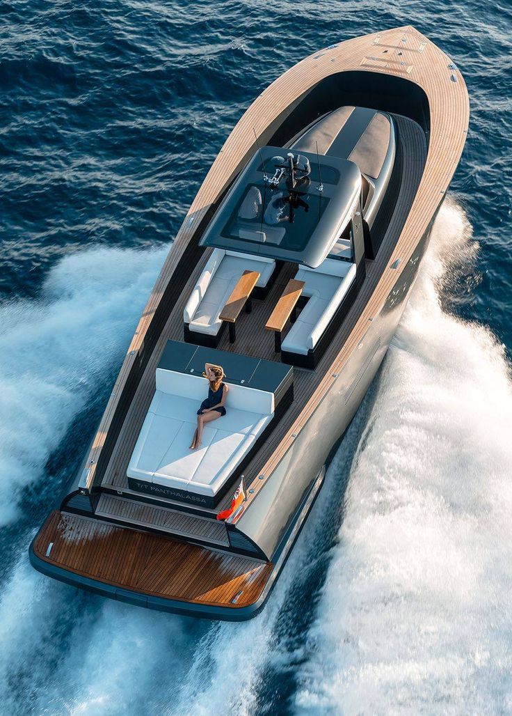 a woman is riding on the back of a small boat in the open water,