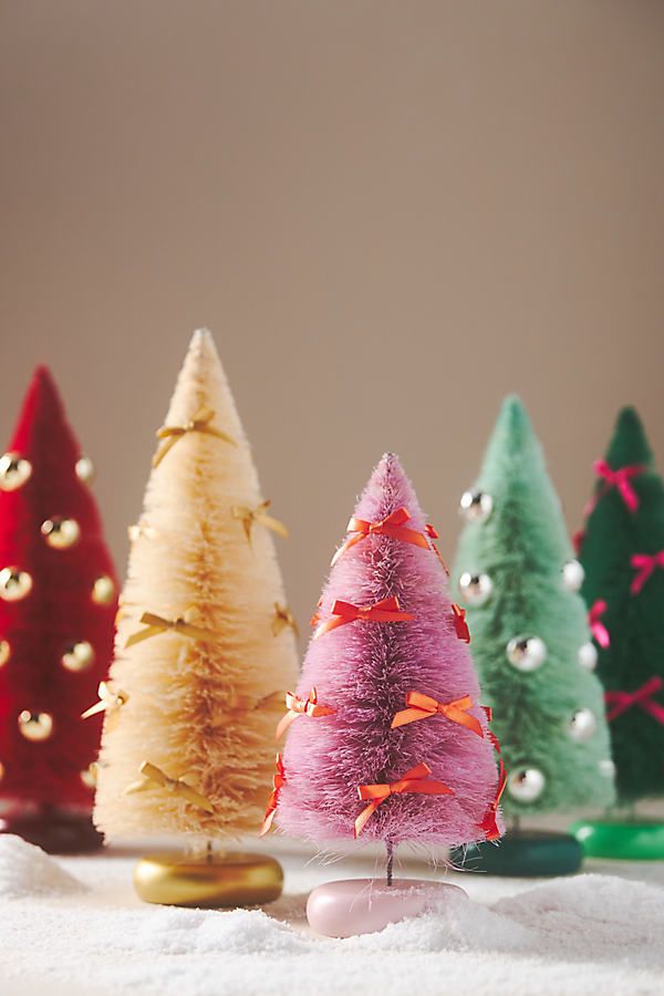 small christmas trees are lined up in the snow