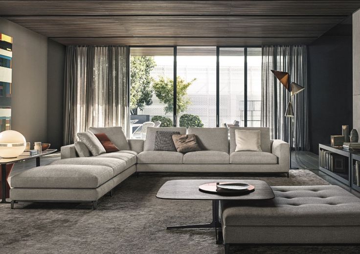 a living room filled with lots of furniture next to a large glass window covered in curtains