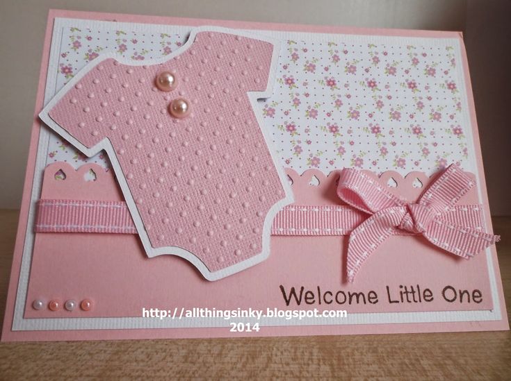 a welcome little one card with a pink baby's outfit on the front and bottom