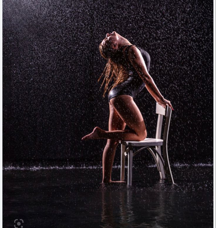 a woman sitting on a chair in the rain