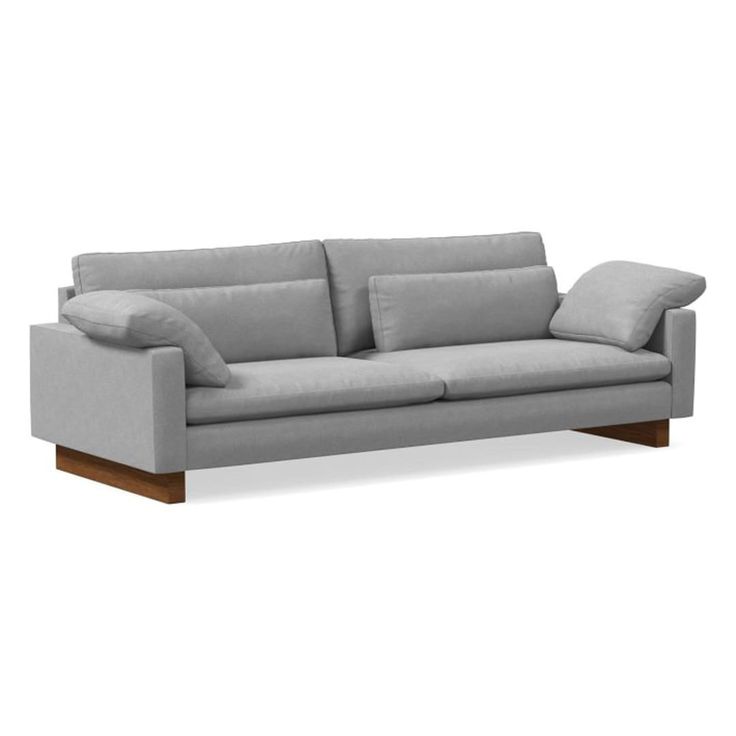 a grey couch with two pillows on the back and one arm folded up in front