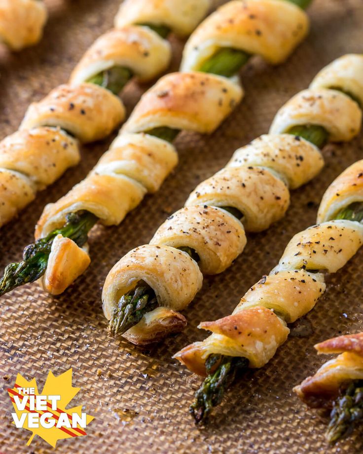 asparagus wrapped in bacon and cheese on a baking sheet