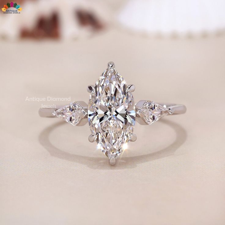 an engagement ring with a pear shaped diamond in the center and three side stones on each side