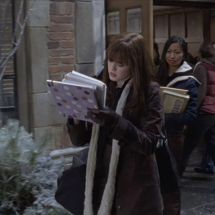 a woman walking down the street while holding books