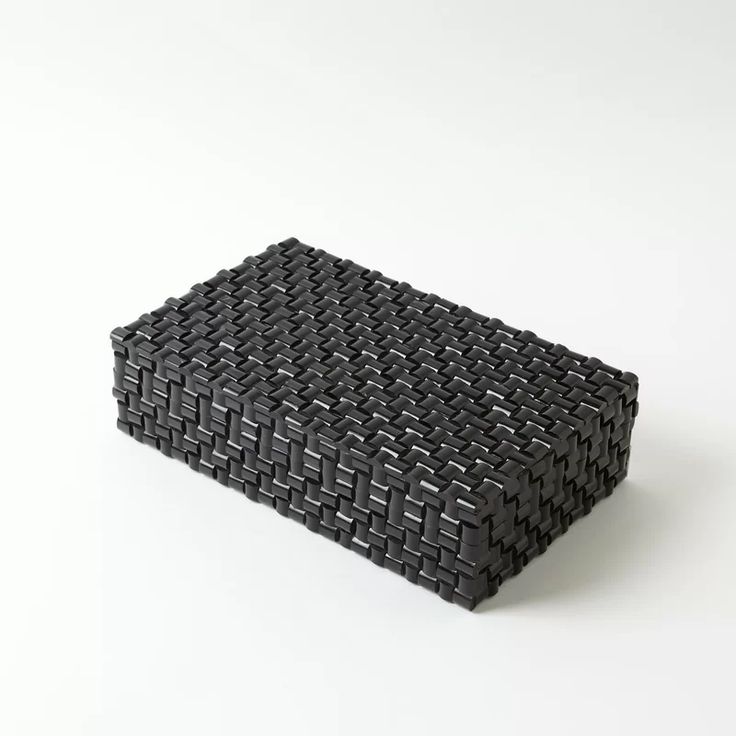 a black basket sitting on top of a white table