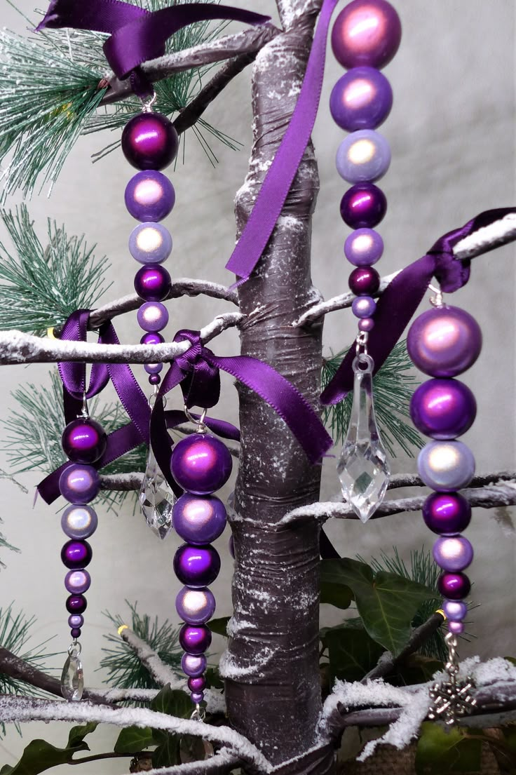 a tree with purple and white ornaments hanging from it's branches