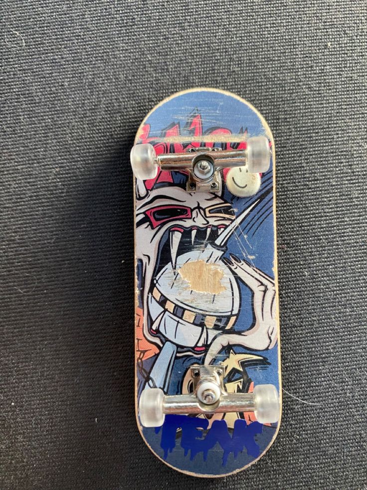 a skateboard with graffiti on it laying on the ground