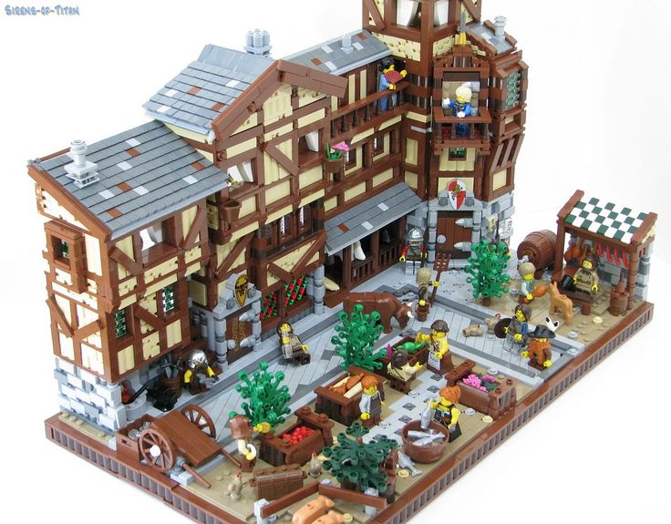 a lego model of a building with horses and people in the front yard, on a white background