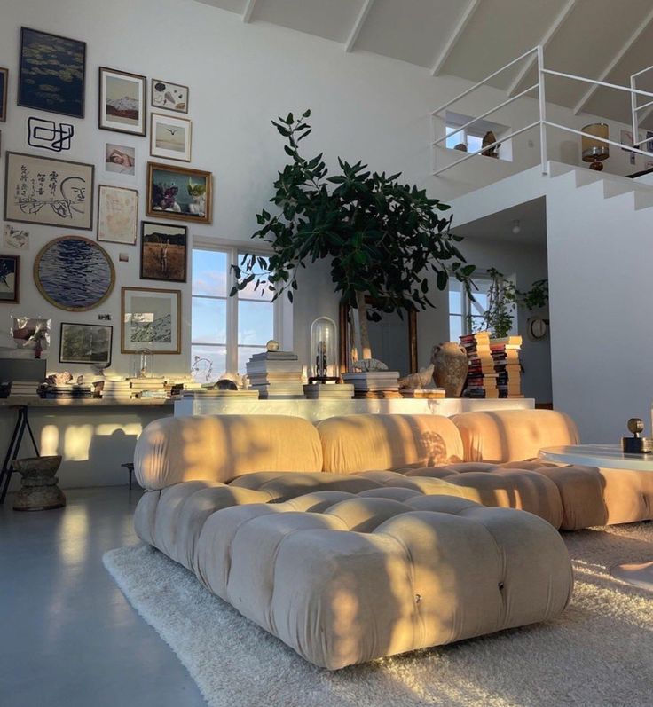 a living room filled with lots of furniture and pictures on the wall above it's windows