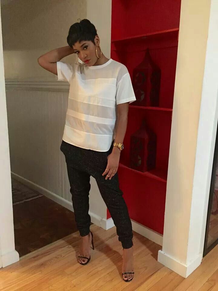 a woman standing in front of a red bookcase with her hand on her head