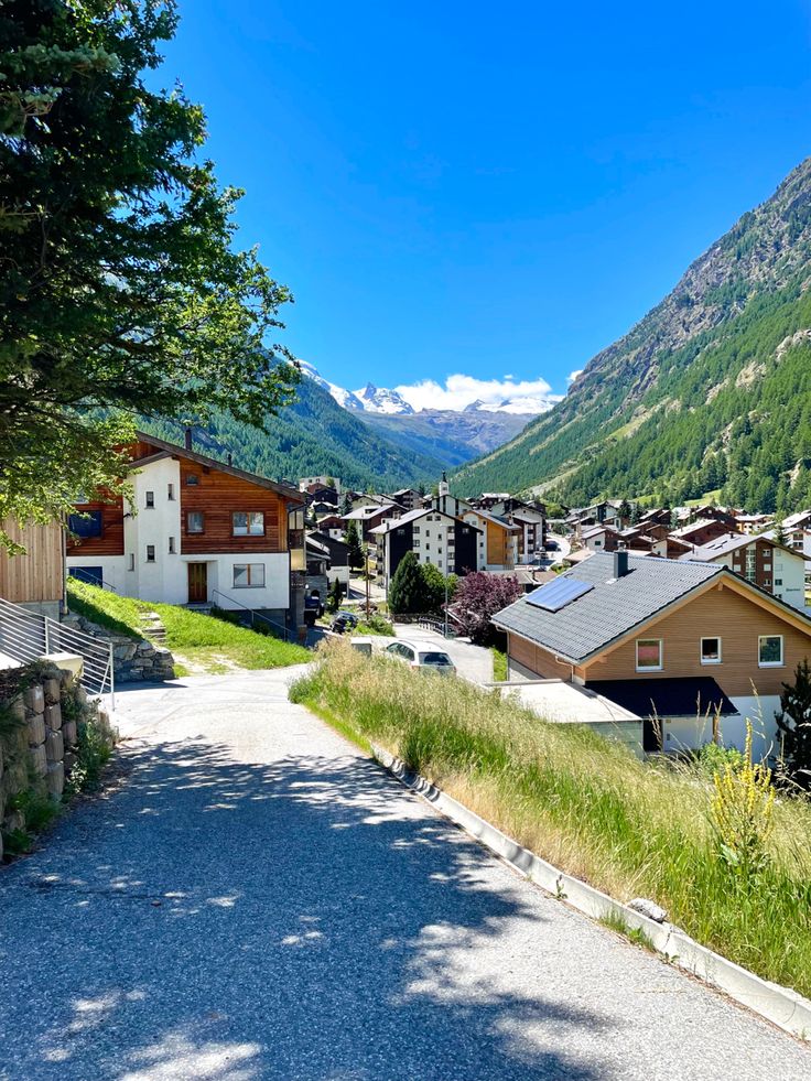 a street with houses and mountains in the background