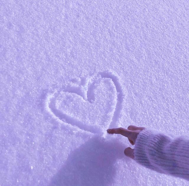 someone is writing a heart in the snow